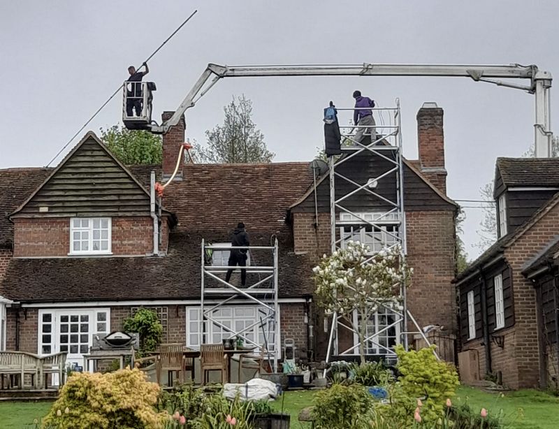 The Roof Moss Cleaners using cherry picker and scaffolding to clean roof safely and professionally in West Chiltington Common, West Sussex